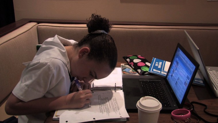 A student featured in the film "Race To Nowhere" studies with the aid of her laptop and coffee.